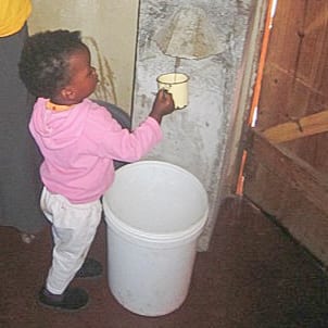 Girl getting water from Biosand Filter